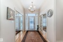 Entrance foyer with crown molding, a chandelier, and light wood-style floors