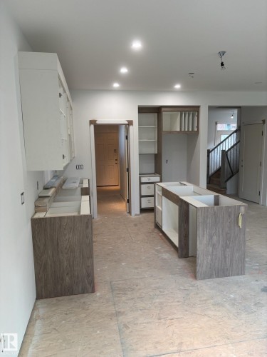 Kitchen cabinetry installation featuring contemporary wood-finish lower cabinets and white upper cabinets