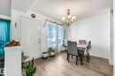 Dining room with a textured ceiling, light wood-type flooring, and a chandelier