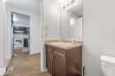 Half bathroom with vanity, light wood-style flooring, and tasteful backsplash