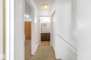 Corridor featuring light carpet and a textured ceiling