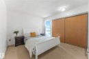 Bedroom with a textured ceiling, light colored carpet, and a closet