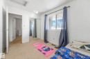 Bedroom with a textured ceiling, a closet, and light carpet