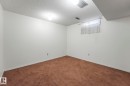 Below grade area featuring a textured ceiling and dark carpet