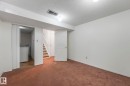 Finished below grade area with a textured ceiling, dark colored carpet, and washer / dryer