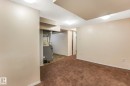 Finished below grade area featuring dark carpet and heating unit