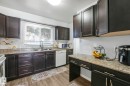 Kitchen featuring white appliances, dark wood-style flooring, light stone countertops, and dark wood finish cabinets