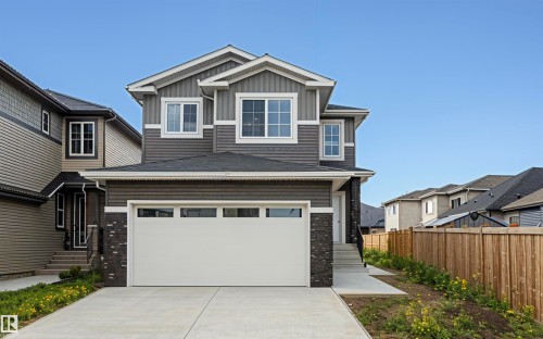 Craftsman-style house with board and batten siding, concrete driveway, and a garage