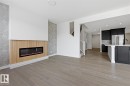Unfurnished living room featuring a glass covered fireplace, light wood finished floors, and recessed lighting