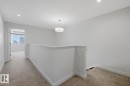 Corridor featuring an upstairs landing, light carpet, and recessed lighting