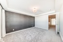 Unfurnished bedroom featuring light carpet, a tray ceiling, and an accent wall