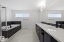 Full bath featuring double vanity, a garden tub, a stall shower, and plenty of natural light