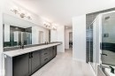 Full bath featuring double vanity, washing machine and clothes dryer, a stall shower, and a spacious closet