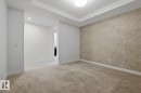 Empty room with light colored carpet and recessed lighting