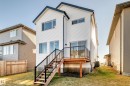 Back of house with a lawn and a wooden deck