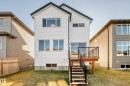 Back of house with a deck and a yard