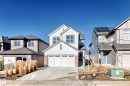 View of front of property with board and batten siding, driveway, and a residential view