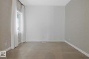 Spare room featuring wallpapered walls and wood finished floors
