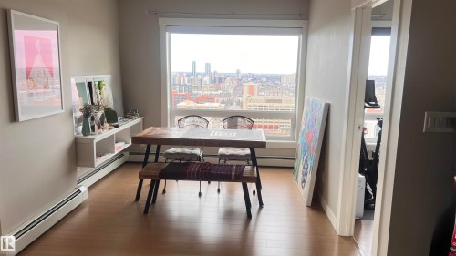 This bright living area features a wide window offering expansive city views and hardwood flooring throughout
