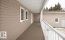 The property features a covered porch with a durable deck surface and white railings, offering an inviting outdoor space