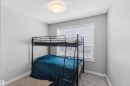 A bright room with neutral wall colors, carpeted flooring, and a window featuring blinds