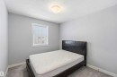 This room features light grey walls, a window with blinds, and grey carpet flooring