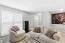 This inviting living space features light gray walls, a large window with blinds, and light-toned flooring