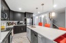 This kitchen features dark wood cabinetry, stainless steel appliances, and a light-colored countertop