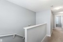 The property features a staircase with a white handrail, leading to a carpeted hallway with light grey walls
