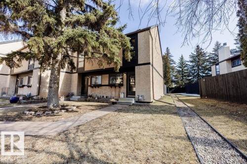 The property features a distinct two-story facade with a large mature tree in the front yard