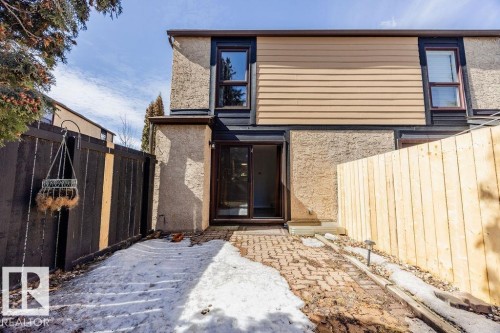 The property features a paving stone patio leading to a glass sliding door entrance