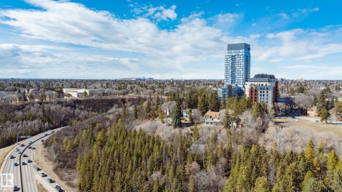 The property is situated within a vibrant community, surrounded by extensive natural landscapes including dense forests and a winding road