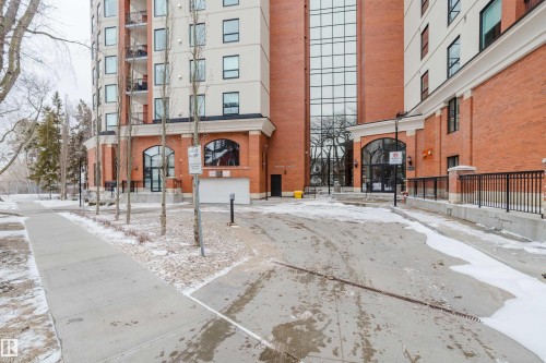The property features an exterior with brick detailing, large arched windows, and a prominent glass facade
