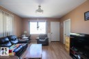 Living area featuring warm neutral wall tones and wood-finish flooring