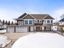 A distinguished two-story property with a warm brown exterior and a dark brown roof