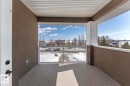 Private balcony with a glass railing and a view of the water and surrounding homes