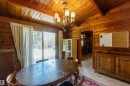 Dining area featuring natural wood paneling, a vaulted wood-finish ceiling, and a chandelier with frosted glass shades
