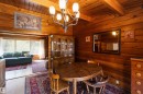 Wood-paneled room featuring a prominent ceiling light fixture, wood-finish flooring, and a built-in display cabinet