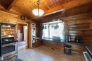Kitchen featuring log walls, wood-finish ceiling, and wood cabinetry