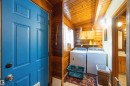 Laundry area featuring wood-paneled walls and ceiling, side-by-side appliances, built-in cabinetry, and a shelf