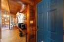 Panel-style interior door with a vibrant blue finish, complemented by an interior featuring warm wood-paneled walls and a matching vaulted ceiling