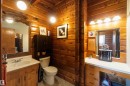 Bathroom featuring extensive wood paneling, a wood vanity with an integrated sink, and an ornate framed mirror
