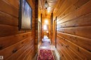 Hallway featuring wood-paneled walls and ceiling, wood-finish flooring, and multiple doorways