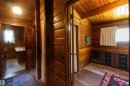 Wood-paneled hallway featuring sloped wood ceilings, wood-finish flooring, and a built-in wooden vanity with black drawers