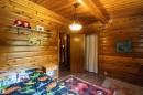 Wood-paneled room featuring a wood-finish ceiling, exposed beam, a built-in shelf, and a ceiling-mounted light fixture