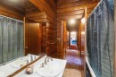 Dual vanities with chrome faucets set against wood-paneled walls and ceiling