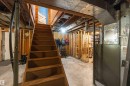 Wood staircase with exposed framing and concrete flooring