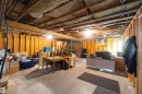 Unfinished basement featuring exposed wood joists, concrete flooring, and framed walls
