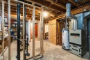 Unfinished basement featuring exposed wood framing, concrete flooring, visible electrical wiring, and plumbing pipes