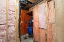 Utility space featuring exposed wood framing, fiberglass insulation, and visible plumbing and electrical lines
